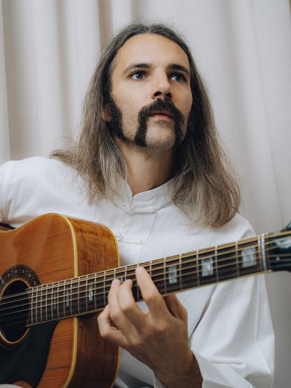 Progressiva Shirt in white, close-up while playing a twelve-string acoustic guitar