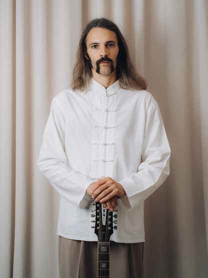 Progressiva Shirt in white with mandarin collar and knotted closures, front view on model