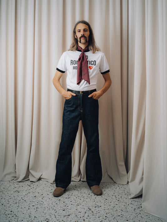 Burgundy ascot worn loose over the Romantico t-shirt and dark indigo jeans, full figure