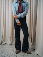 Damerino Ascot in burgundy knotted over a light blue shirt and dark indigo jeans
