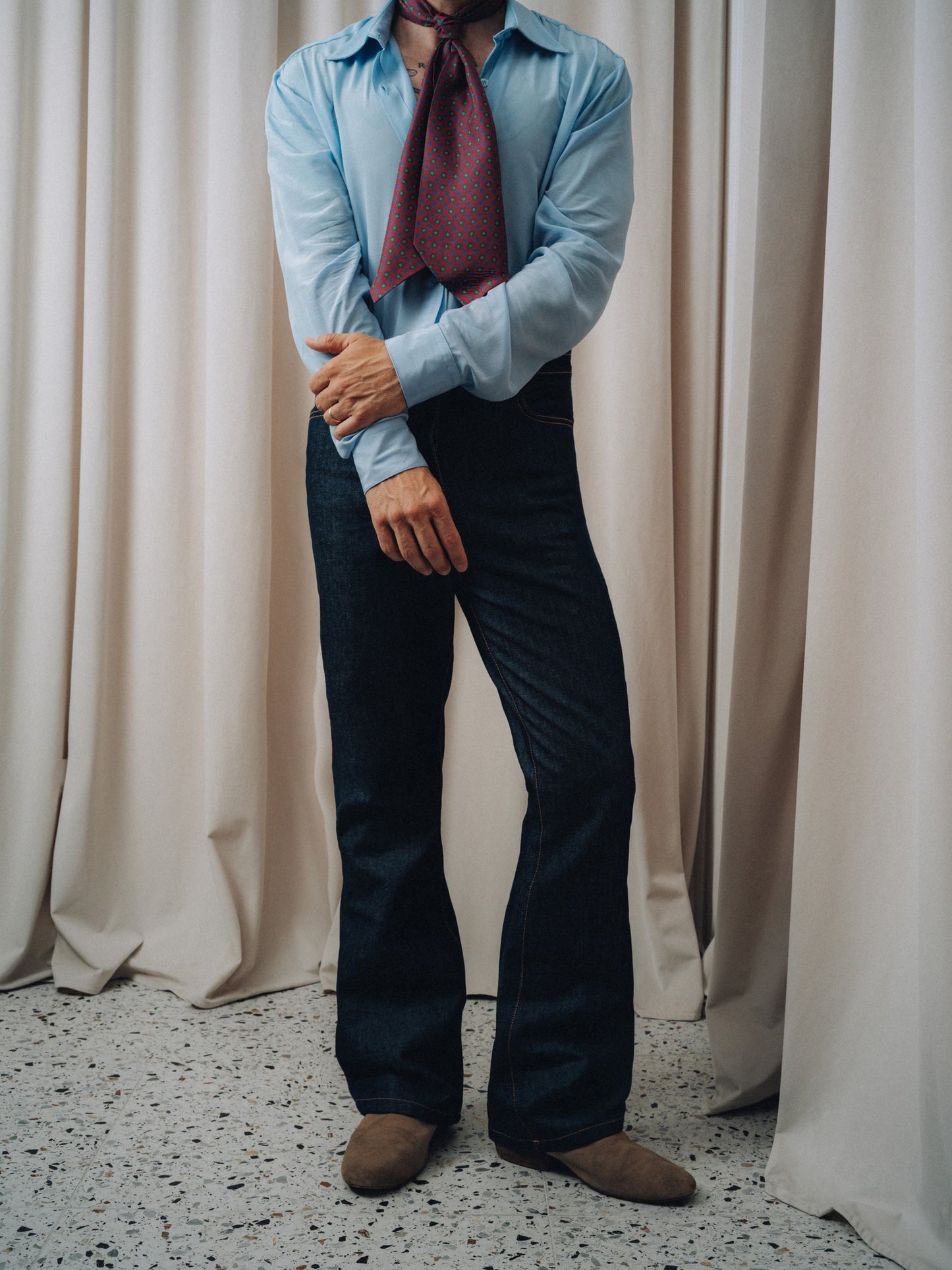 Damerino Ascot in burgundy knotted over a light blue shirt and dark indigo jeans