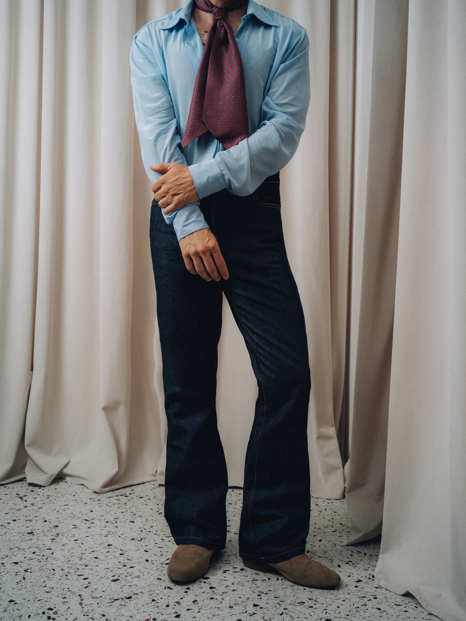 Damerino Ascot in burgundy knotted over a light blue shirt and dark indigo jeans