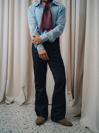 Damerino Ascot in burgundy knotted over a light blue shirt and dark indigo jeans