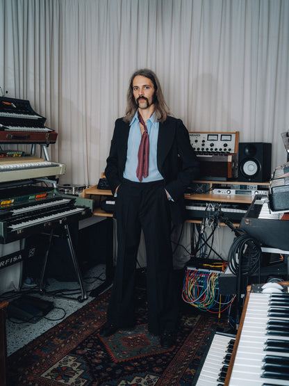 Black Dancing Balera jacket and matching trousers with a burgundy ascot in a synthesizer studio